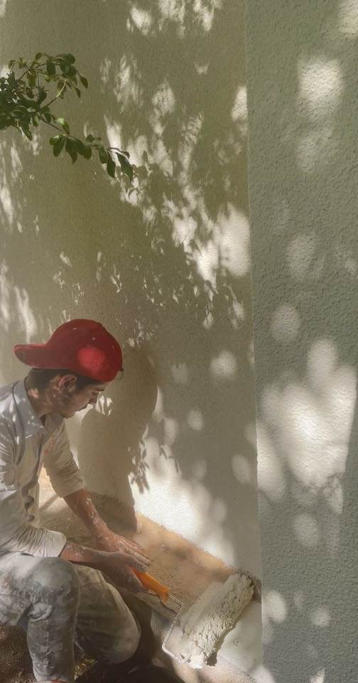 Painter rolling a fresh coat onto an exterior wall