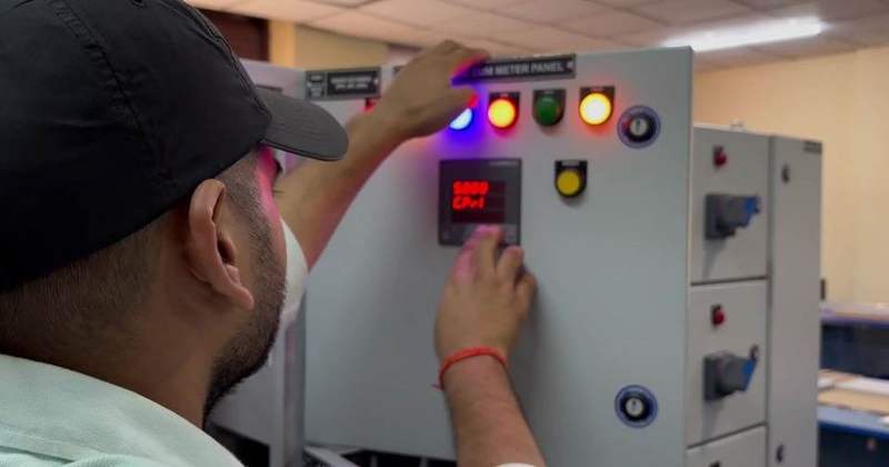 Technician adjusting an HVAC control panel
